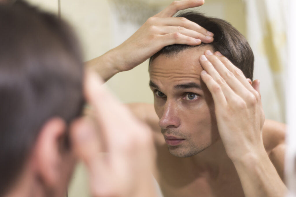 men looking in the mirror catching hair